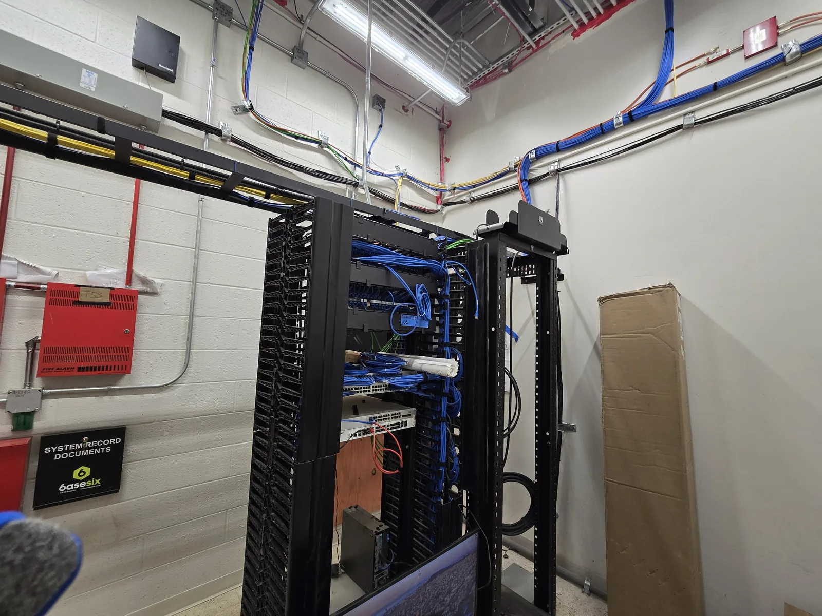Commercial network room with structured cabling pathways and equipment racks.